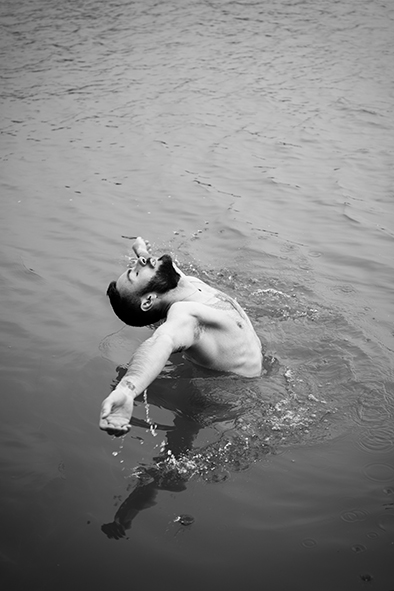 portrait homme dans un lac ouvrant les bras vers le ciel.