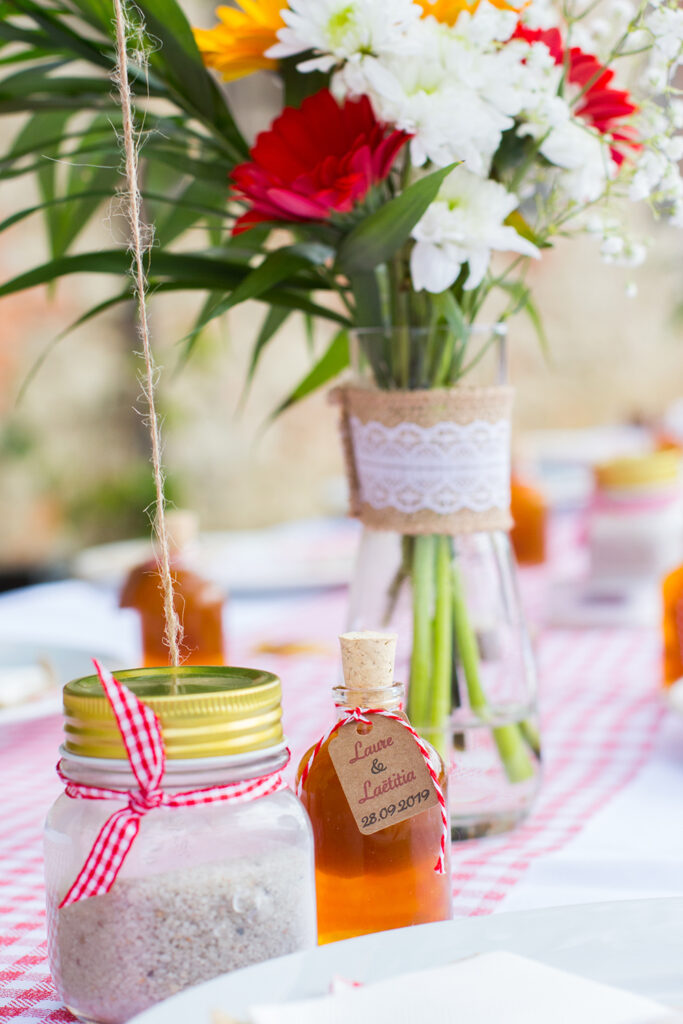 details d'un table de mariage qui met en avant le cadeau pour les invites, une eptite bouteille de rhum.